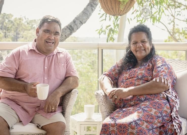 Maori couple smiling on a balcony